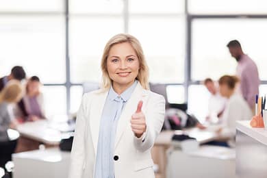 happy businesswoman showing thumbs up at office